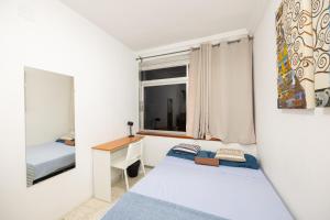 a small bedroom with two beds and a desk at Kite & Surf Nomad House in Las Palmas de Gran Canaria
