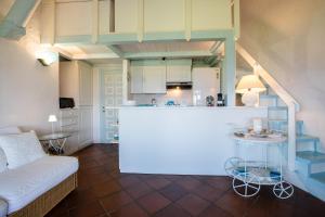 a living room with a couch and a kitchen at PORTO ROTONDO SPLENDIDO APPARTAMENTO VISTA MARE in Porto Rotondo