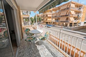 einen Balkon mit einem Tisch und Stühlen sowie ein Gebäude in der Unterkunft Apartamento en Gran Playa in Santa Pola