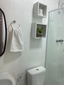 biała łazienka z toaletą i umywalką w obiekcie Flat próximo ao Centro de CG com Wifi rápida w mieście Campina Grande