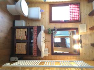 Zimmer mit Holzwänden, einem Fenster und einem Spiegel in der Unterkunft Chalet de montaña in Bolquere