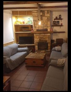 a living room with couches and a stone fireplace at Casa Rural El PARADOR in Carcelén