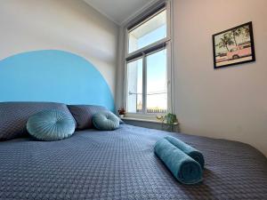 a bedroom with a bed with blue pillows and a window at MMRent Miami Room in Gdańsk