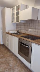 黑林山區孔尼斯費德的住宿－Ferienwohnung Ruhequell，厨房配有白色橱柜和炉灶烤箱。