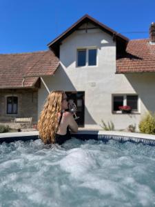 une femme est assise dans une piscine dans l'établissement Útulné spaní ve venkovské chaloupce s vířivkou, à Podbřezí