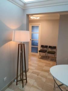 Habitación con lámpara, mesa y sillas en Appartement meublé de 77 m² Champigny-Sur-Marne, en Champigny-sur-Marne