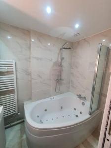 y baño blanco con bañera y ducha. en Appartement meublé de 77 m² Champigny-Sur-Marne, en Champigny-sur-Marne