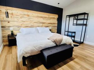 1 dormitorio con 1 cama grande y pared de madera en Penthouse Suite at Meadow View!, en Show Low