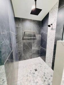 y baño con ducha alicatada. en Penthouse Suite at Meadow View!, en Show Low