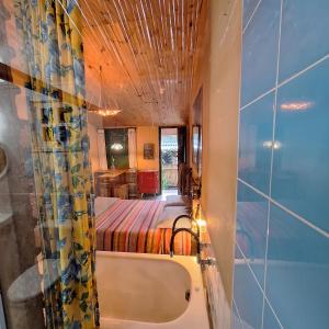 ein Bad mit Badewanne und ein Bett in einem Zimmer in der Unterkunft Diógenes Pousada in Conceição da Ibitipoca