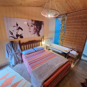 ein Schlafzimmer mit einem Bett und einem Wandgemälde in der Unterkunft Diógenes Pousada in Conceição da Ibitipoca