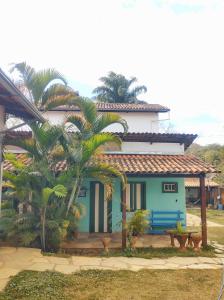 a house with a palm tree in front of it at Pousada Batihá - beira rio in Pirenópolis