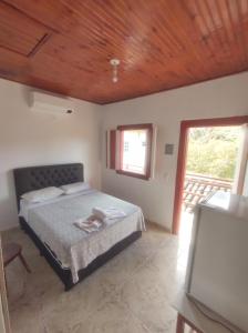 a bedroom with a bed and a wooden ceiling at Pousada Batihá - beira rio in Pirenópolis