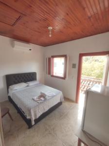 a bedroom with a bed with a wooden ceiling at Pousada Batihá - beira rio in Pirenópolis