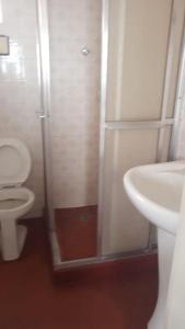 a bathroom with a shower and a toilet and a sink at Apto Central Barra de Imbé in Imbé