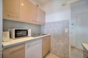 a kitchen with a sink and a microwave at IMMOGROOM - 1 Bedroom - Terasse - Sea View - AC - Wifi in Cannes
