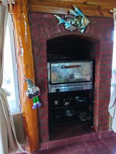 un televisor en una chimenea de ladrillo con un pez. en Cabañas LuCes del Pirque 2 en El Hoyo