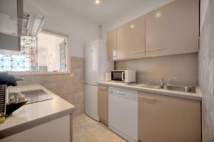 a kitchen with white cabinets and a sink and a microwave at IMMOGROOM - 1 Bedroom - Terasse - Sea View - AC - Wifi in Cannes