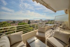 balcón con muebles blancos y vistas a la ciudad en IMMOGROOM - 1 Bedroom - Terasse - Sea View - AC - Wifi, en Cannes