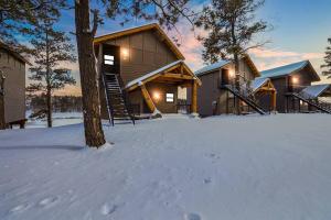 une cabine dans la neige avec un arbre au premier plan dans l'établissement Perfect Luxury Getaway, à Show Low