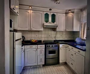 a white kitchen with white cabinets and appliances at Samadri in Arequipa +43 photos