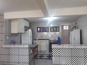 uma cozinha com electrodomésticos brancos e azulejos pretos e brancos em Chácara São Vicente em Pedro de Toledo-SP em Pedro de Toledo