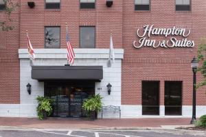 蓋恩斯維爾的住宿－Hampton Inn & Suites Gainesville Downtown，两面美国国旗砖楼前的商店