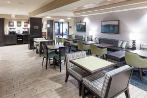 a waiting room with tables and chairs and a restaurant at Hampton Inn & Suites Gainesville Downtown in Gainesville
