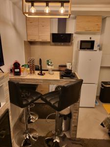 a kitchen with a counter and two bar stools at Lovely studio -paris in Bagnolet