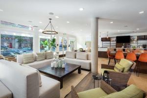 a living room with white couches and a table at Hilton Garden Inn Davis Downtown in Davis