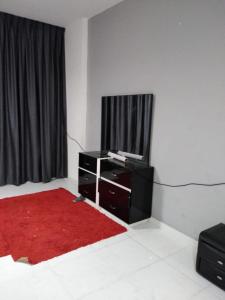 a living room with a tv and a red rug at Studio Apartment in Ajman 