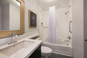 a bathroom with a sink and a toilet and a tub at Sonesta Simply Suites Jersey City in Jersey City