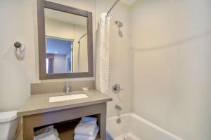 a bathroom with a sink and a mirror and a tub at Studio 6 Rosemead, CA in Rosemead