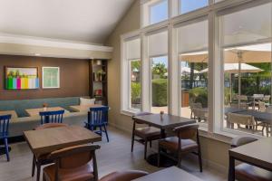 a restaurant with tables and chairs and windows at Sonesta ES Suites San Francisco Airport Oyster Point Waterfront in South San Francisco
