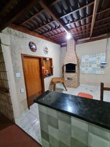 a kitchen and living room with a brick fireplace at POUSADA POR DO SOL in Olímpia