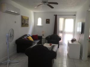 a living room with two couches and a ceiling fan at The Point in Orange Bay