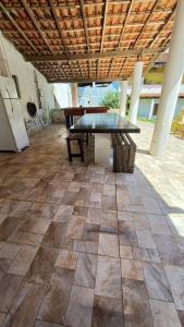 un patio con una mesa y un banco en un suelo de baldosa en Chácara São Vicente em Pedro de Toledo-SP en Pedro de Toledo