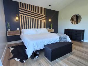 a bedroom with a large bed and a black ottoman at Luxurious Mountain Retreat! in Show Low