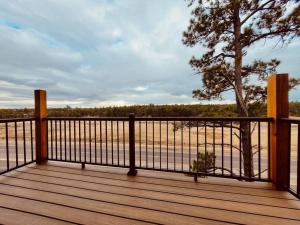 a wooden deck with a fence and a tree at Luxurious Mountain Retreat! in Show Low