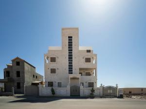 um grande edifício branco com um portão em frente em ENG-Murjan Apartment em Aqaba