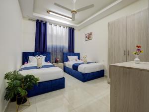ENG-Murjan Apartment في العقبة: سريرين في غرفة باللون الأزرق والأبيض