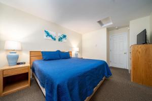 a bedroom with a blue bed and a television at Waters Edge 402 in Lincoln City