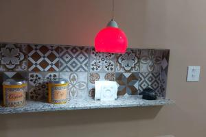 a room with a counter with two cans and a red light at Apartamento encantador- 40 metros da praia e duas quadras do shopping in Santos