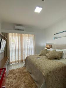 a bedroom with a large bed and a window at Flat Beira Mar Piedade in Recife