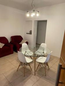 a dining room with a glass table and white chairs at Liban 1 in San Juan