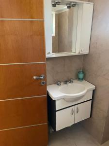 La salle de bains est pourvue d'un lavabo, d'un miroir et d'une porte. dans l'établissement Liban 1, à San Juan