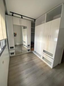 an empty room with white cabinets and wood floors at Appartement avec suite parentale in Mohammedia