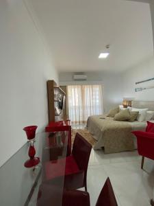 a bedroom with a bed and a red chair at Flat Beira Mar Piedade in Recife