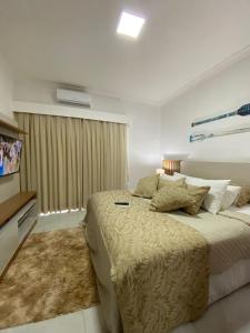 um quarto com uma cama grande e uma televisão em Flat Beira Mar Piedade em Recife