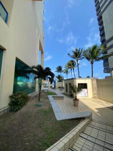 um edifício com palmeiras em frente a um edifício em Flat Beira Mar Piedade em Recife